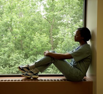 Sad girl sitting next to a window